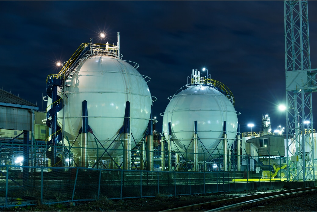 Night time view of industrial installation with spherical storage containers