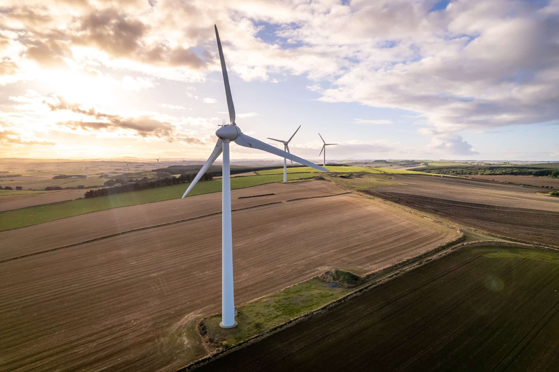 Wind turbines in countryside at sunset