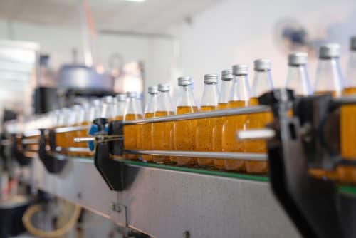 Conveyer belt of orange bottles