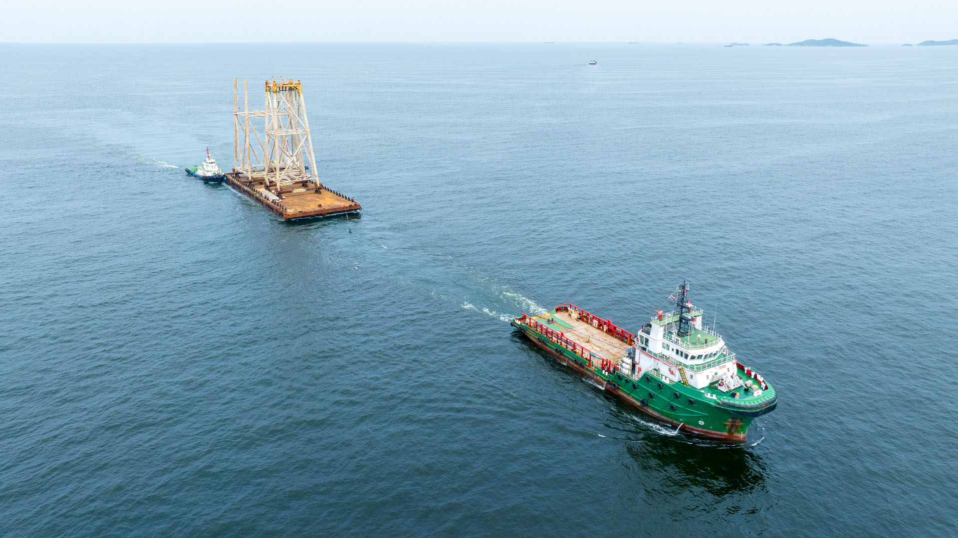 Tugboat pulling barge out at sea